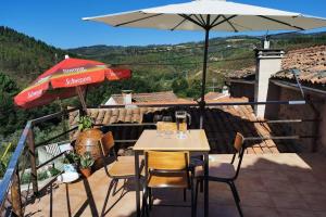 un patio con un tavolo e un ombrellone di Casa do Linho 400 year old country cottage a Oleiros