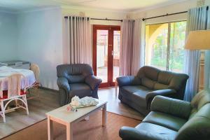 a living room with two couches and a table at First Group La Rochelle in St Lucia