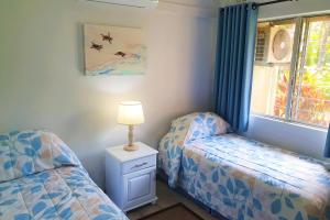 1 dormitorio con 2 camas y mesita de noche con lámpara en First Group La Rochelle, en St Lucia