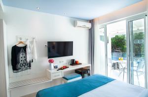 a bedroom with a bed and a tv on a wall at Acrotel Lilyann Boutique Hotel in Elia