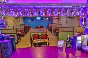 a dining room with purple lights and chairs and a table at Hotel TamilNadu - Madurai I in Madurai