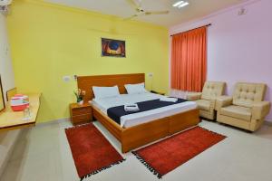 a bedroom with a bed and a couch and a chair at Hotel TamilNadu - Madurai I in Madurai