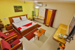 a bedroom with a bed and a table and chairs at Hotel TamilNadu - Madurai I in Madurai