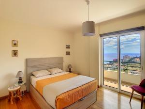 - une chambre avec un lit et une grande fenêtre dans l'établissement VeBella Ocean View by LovelyStay, à Caniço