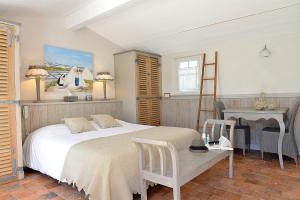 a bedroom with a bed and a desk and a ladder at Hotel Les Bois Flottais in Le Bois-Plage-en-Ré