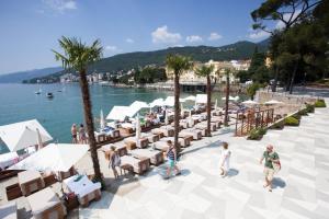 a group of people walking around a beach with tables and chairs at Apartment Tomy in Rijeka