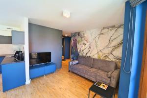 Televízia a/alebo spoločenská miestnosť v ubytovaní Apartamenty EverySky Nad Łomnicą 15-15A