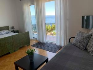 a living room with a couch and a view of the ocean at BEACH SEA VIEW APPARTMENT in Podgora