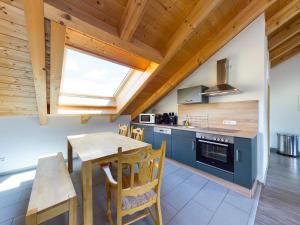 kuchnia z drewnianym stołem i drewnianym sufitem w obiekcie Bergspitzen w Garmisch Partenkirchen