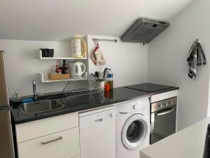 a kitchen with a sink and a washing machine at Casa Foz Marina in Figueira da Foz