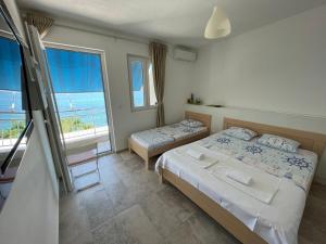 1 dormitorio con 2 camas y vistas al océano en Two Palms Apartment en Sutomore