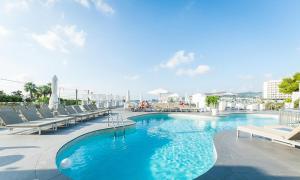 una piscina con tumbonas y un hotel en Typic Marina Playa - Adults Only en San Antonio Bay