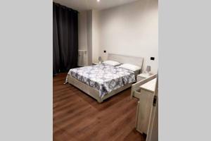 1 dormitorio con 1 cama y suelo de madera en Appartamento Gisella, en Asti