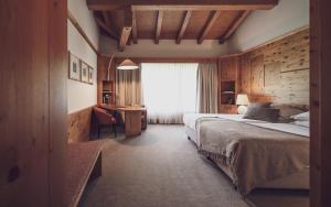 达沃斯Hotel Waldhuus的一间卧室，配有一张床、一张书桌和一扇窗户