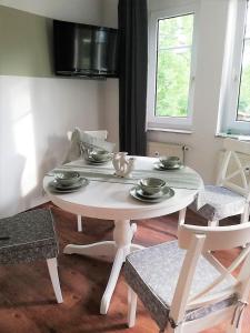 Ferienwohnung Am Kurpark في باد كلوسترلاوسنيتز: طاولة بيضاء وكراسي في غرفة المعيشة