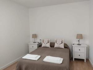 um quarto com uma cama grande e 2 mesas de cabeceira em A Apartamentos Diego em O Grove