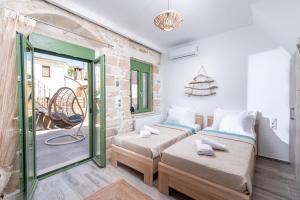 a bedroom with two beds and a balcony at Katina's House in Petrokefálion