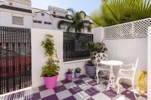 un patio avec une table, des chaises et des plantes en pot dans l'établissement STUDIO -PATIO ANDALUZ-, à Marbella