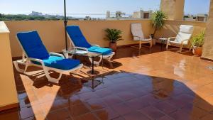 Un patio con sillas y una mesa en el balcón. en Ático con terraza abierta/Open terrace apartment, en Mijas