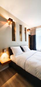 um quarto com uma grande cama branca e uma janela em Villa les érables Restaurant Linea em Spa