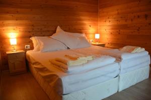 Bett in einem Holzzimmer mit Handtüchern darauf in der Unterkunft Villa Viridi in Sozopol