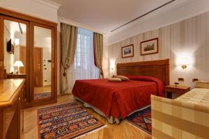 Habitación de hotel con cama roja y baño. en Residenza RomaCentro, en Roma
