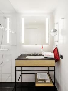 a white bathroom with a sink and a shower at IntercityHotel Zürich Airport in Rümlang