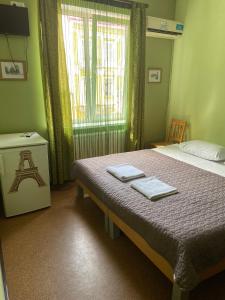 a bedroom with a bed with two towels on it at Hotel Kardinal in Vinnytsya
