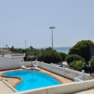 uitzicht op een zwembad en de oceaan bij Casa Lucia in Puerto del Carmen