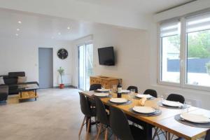 a living room with a large wooden table and chairs at Maison de 2 à 8 personnes 5 chambres in Portbail