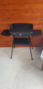 a grill sitting in a room with a wooden wall at Privat DAŇO in Lisková