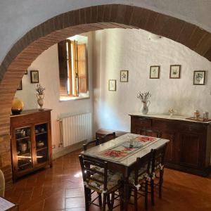 a kitchen with a table and some chairs in a room at La Casina in Buonconvento