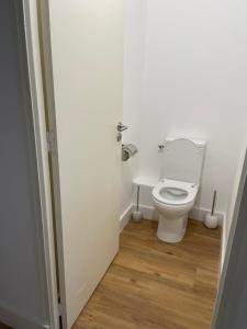 La salle de bains est pourvue de toilettes blanches et de parquet. dans l'établissement Appartement neuf, 2 chambres, climatisé, route des Sanguinaires, à Ajaccio