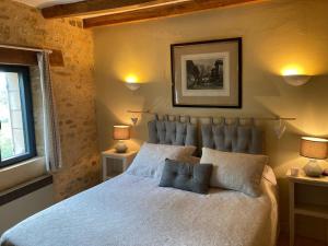 um quarto com uma cama grande e 2 candeeiros em Gîte Le Recoux em Mouzens