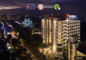 a lit up city at night with a tall building at Swiss-Belboutique Yogyakarta in Yogyakarta