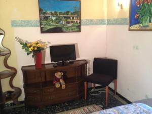 una camera con TV su un comò e una sedia di Hotel Comodoro a Portbou