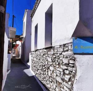 a street in a village with a stone wall at Giagia Annousio in Dhriopís