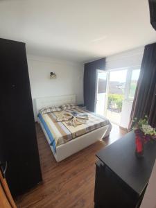 a bedroom with a bed and a table and a window at Vila Dana in Costinesti