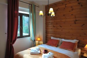 a bedroom with a large bed with a wooden headboard at Vaela Hotel Cultural Resort in Elatochori
