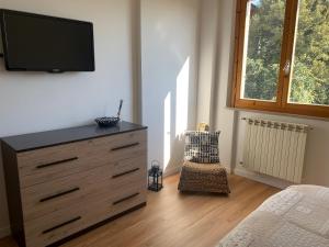 a bedroom with a dresser with a television on a wall at SMartspot Rosia in Rosia