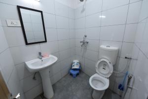 a bathroom with a sink and a toilet and a mirror at Hotel Mayur in Gorakhpur