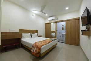 a bedroom with a bed and a desk and a television at Hotel Mayur in Gorakhpur