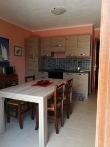 - une cuisine avec une table et des chaises en bois dans l'établissement Residence degli ulivi, à Ossi