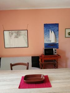 une chambre avec une table et un bateau sur le mur dans l'établissement Residence degli ulivi, à Ossi