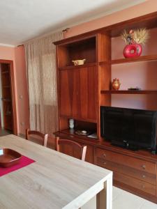 un soggiorno con un ampio centro di intrattenimento con TV a schermo piatto di Residence degli ulivi a Ossi