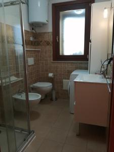 La salle de bains est pourvue de toilettes, d'un lavabo et d'une douche. dans l'établissement Residence degli ulivi, à Ossi