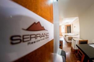 a hotel room with a hotel sign on the wall at Serrano Residencial Hotel in Juiz de Fora