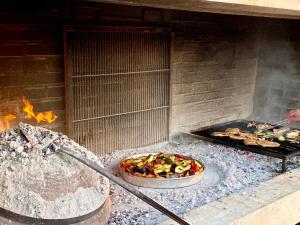 a pizza is cooking in an outdoor oven at Guesthouse Gradina in Lovište