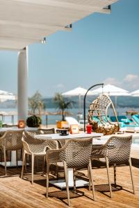 un patio con mesas y sillas y una piscina en Trabukos Beach Complex, en Kavos