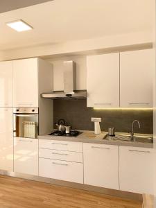 a kitchen with white cabinets and stainless steel appliances at SMartspot Rosia in Rosia